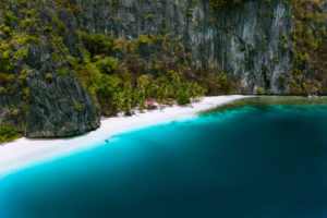 El Nido, Palawan, Philippines. Aerial drone view of solitude tropical hut on Pinagbuyutan Island. Amazing white sand beach with turquoise blue lagoon water. El Nido, Palawan, Philippines. Aerial drone view of solitude tropical hut on Pinagbuyutan Island. Amazing white sand beach with turquoise blue lagoon water.